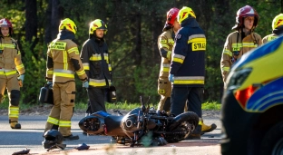 Wypadek na łuku drogi w lesie. Motocykl zderzył się z autem